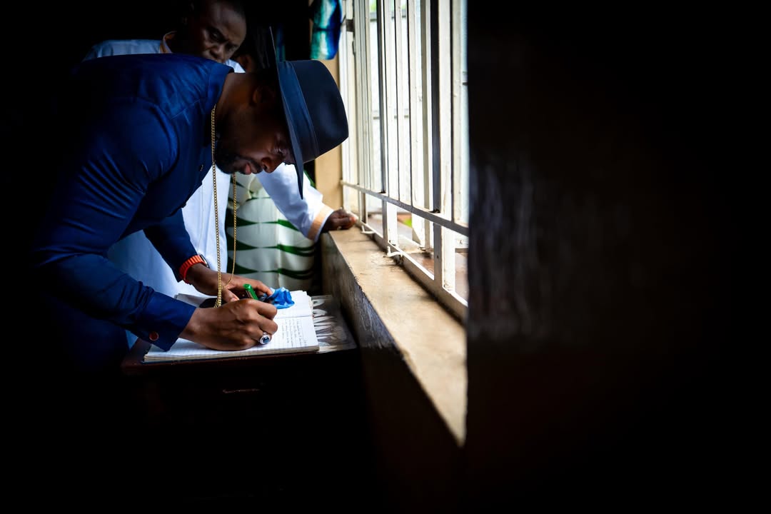 His Majesty signing a visitor register in Sierra Leone