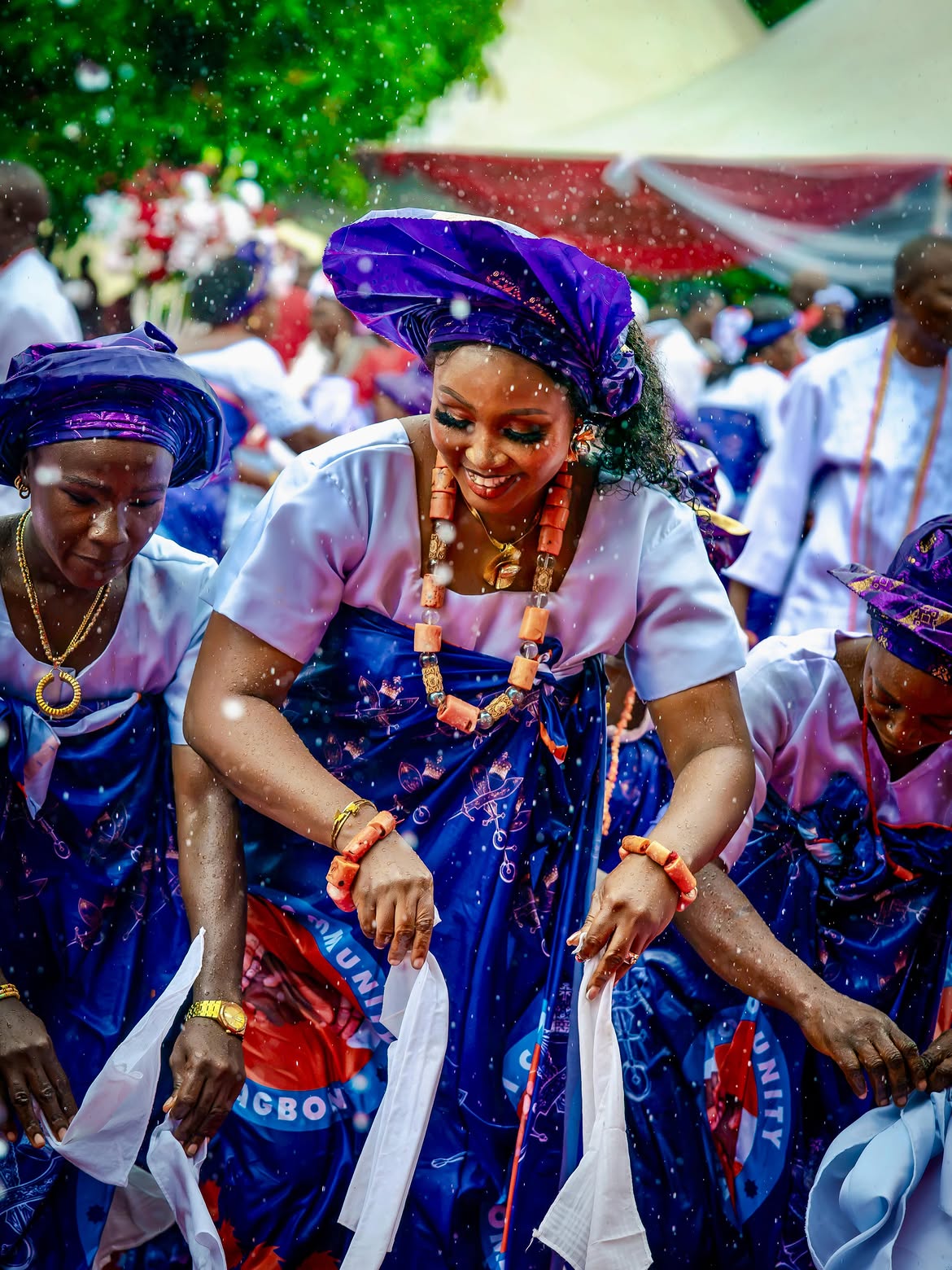 Bobi community women dancing amid light showers