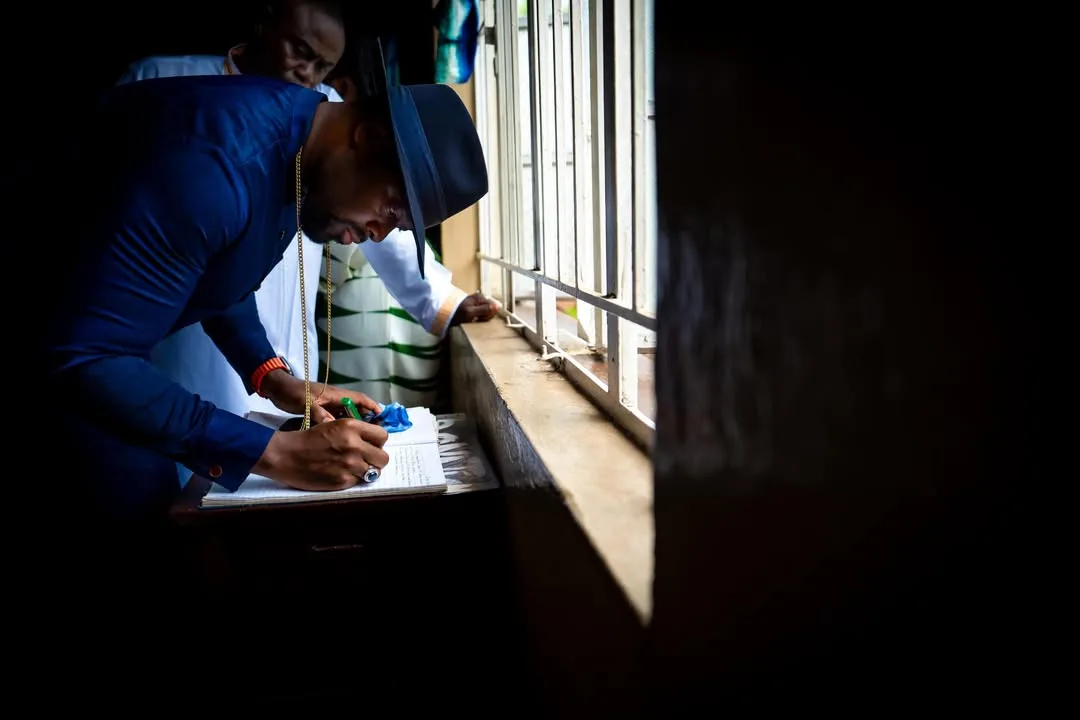 His Majesty signing a visitor register in Sierra Leone